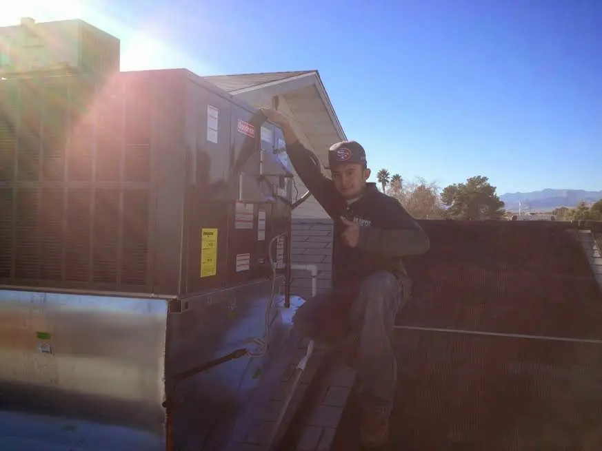 HVAC technician performing Air Duct Repair on a rooftop unit in Reedurban